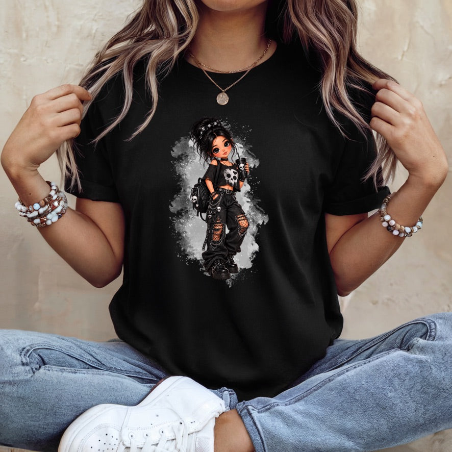A woman wearing a black short-sleeve graphic t-shirt with a detailed illustration of a gothic anime-style girl in a black and white outfit, paired with light blue jeans and white sneakers.