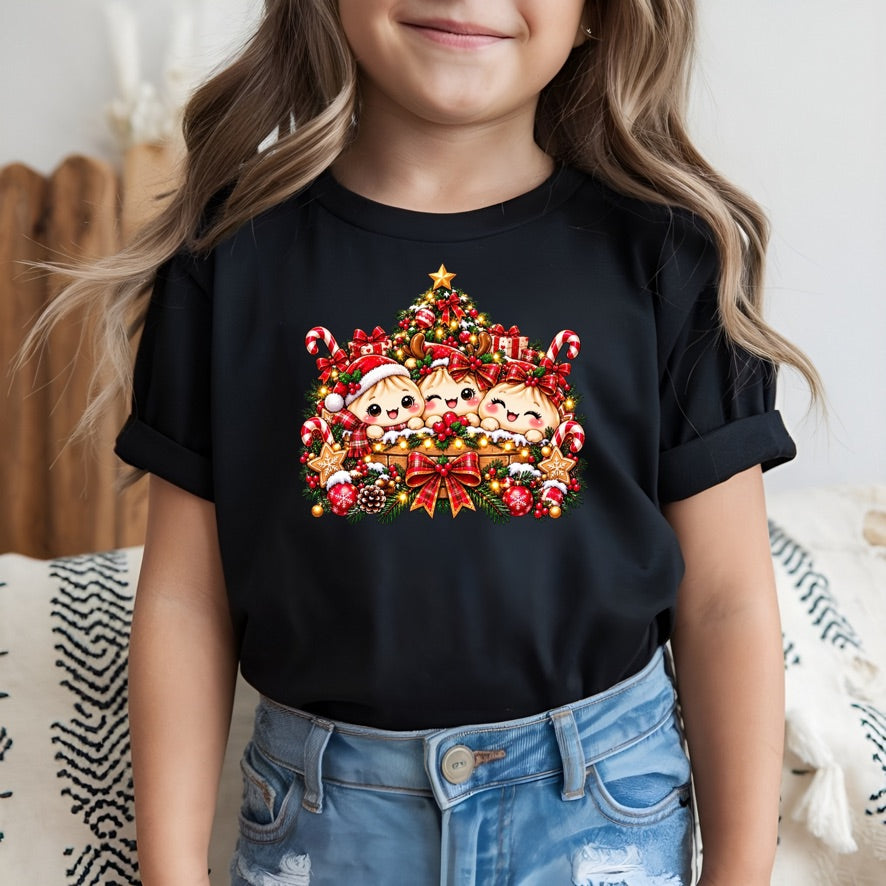 A child wearing a black short-sleeve T-shirt with a colorful Christmas graphic of Santa Claus and children under a decorated tree, paired with light blue jeans.