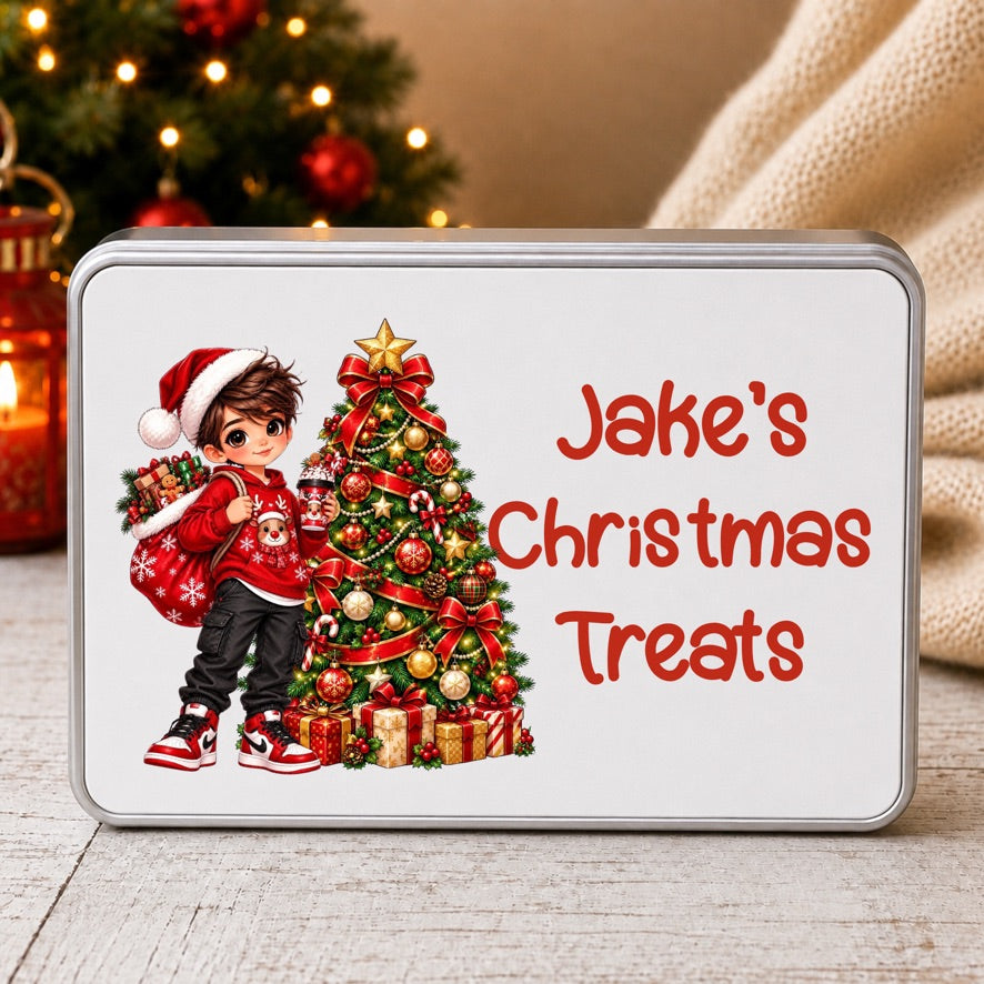 A rectangular tin of Christmas treats with a custom printed design. The design features an illustration of a young boy in a Santa hat next to a decorated Christmas tree, with the text 'Jake's Christmas Treats' in red.