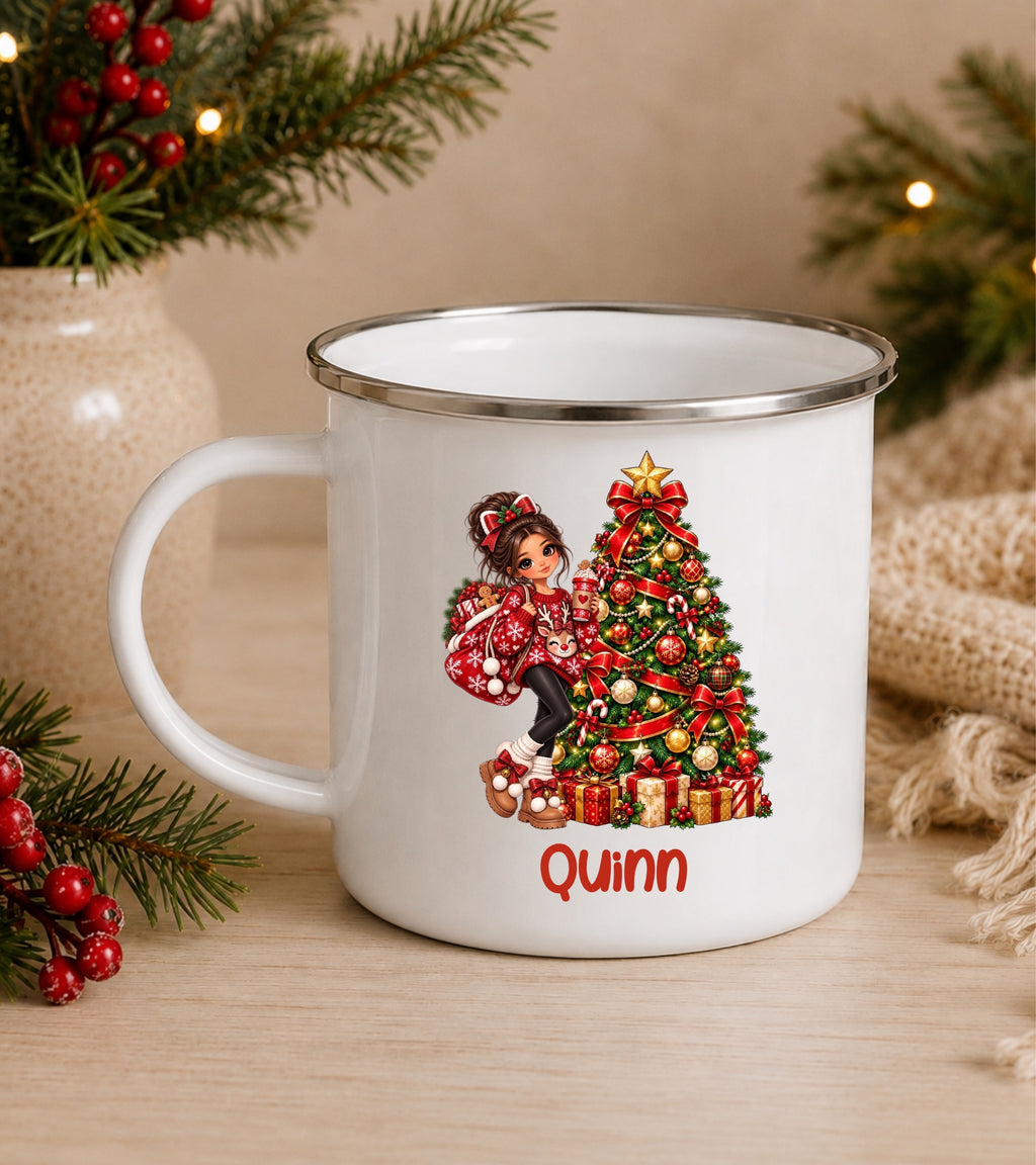 A white enamel-style mug with a silver rim, featuring a Christmas tree illustration and the name 'Quinn' in red text. The mug is styled on a wooden surface with holiday greenery, red berries, and a knitted textile in the background.