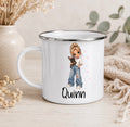 A white enamel-style mug with a silver rim sits on a light wood surface. The mug is printed with an illustration of a girl with blonde hair holding a small black dog, with pink stars and the name 'Quinn' in black script below.
