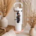 A white insulated tumbler with a lid and carry handle, held in a hand. The tumbler features a graphic of a gothic girl in black clothing holding a skull, with the name 'GUILLEN' printed below.