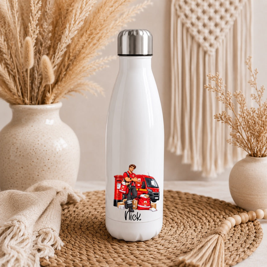 A white insulated water bottle with a silver cap stands on a woven mat in a styled indoor setting. The bottle has a printed illustration of a firefighter standing beside a red fire truck, with the name 'Nick' written below.